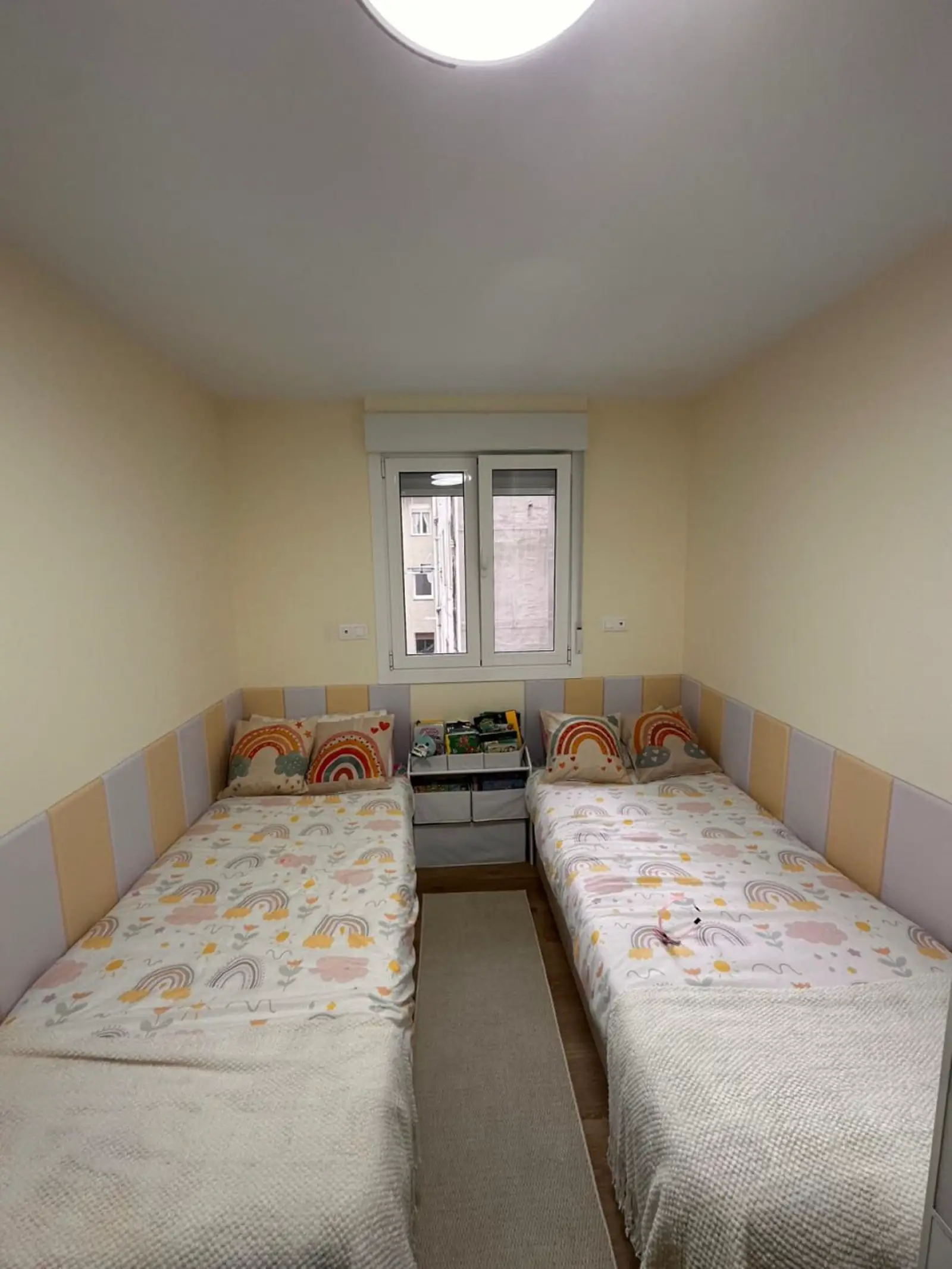 Dormitorio infantil reformado con suelo laminado y ventana renovada