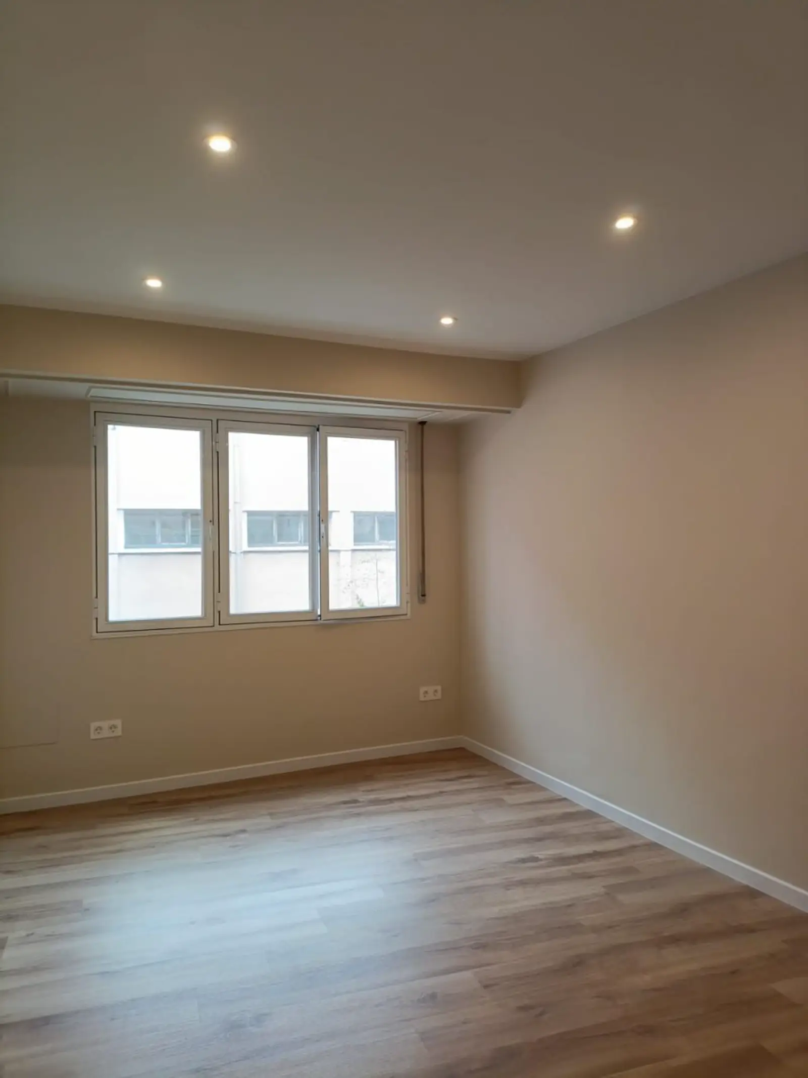 Salón reformado con suelo de madera y techo revestido